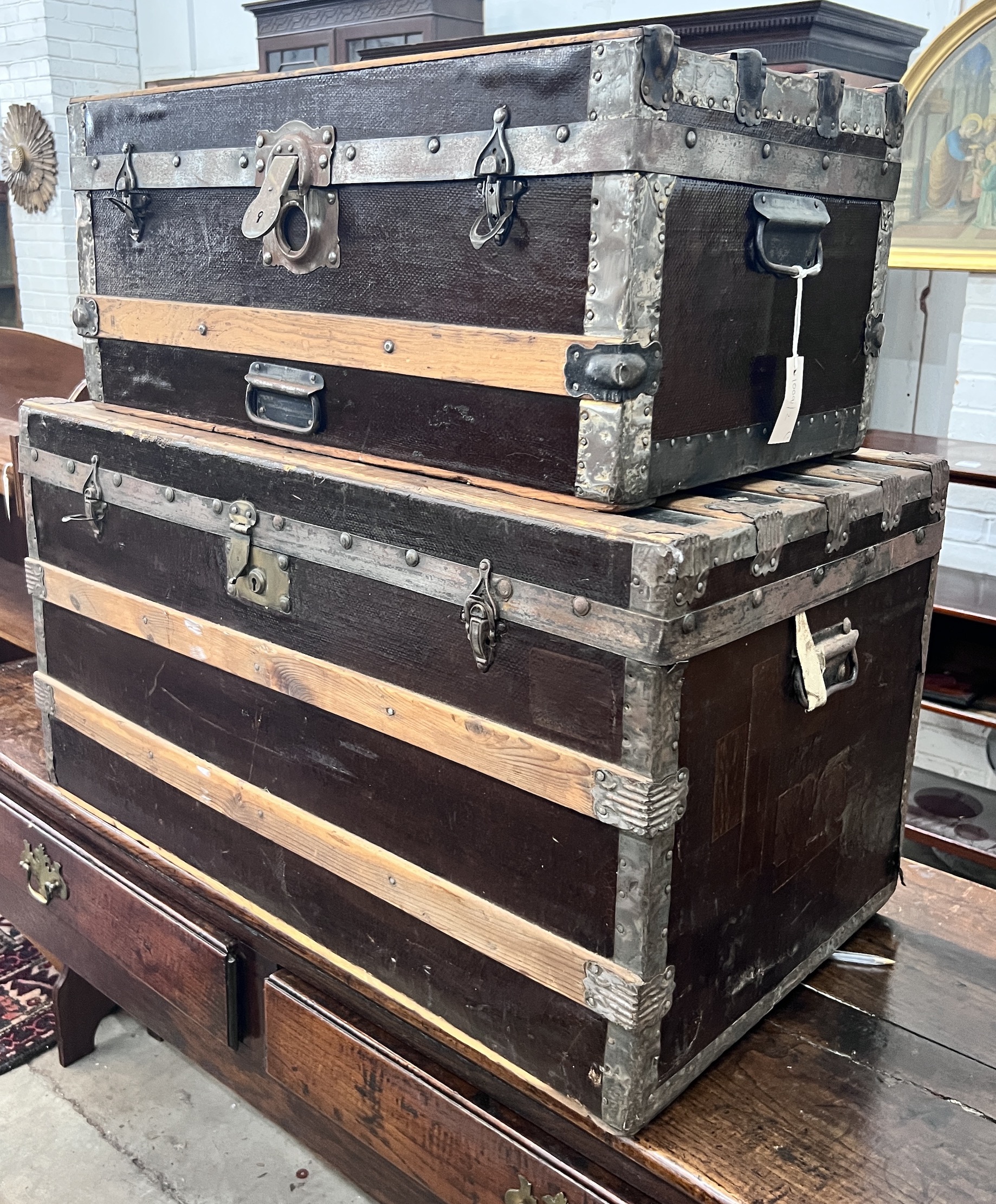 Two wood and metal bound travelling trunks, larger length 86cm, depth 48cm, height 47cm